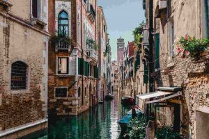 Italia. Fotografia di un canale di Venezia con edifici in pietra su entrambi i lati. La foto è stata scattata da una tipica gondola.